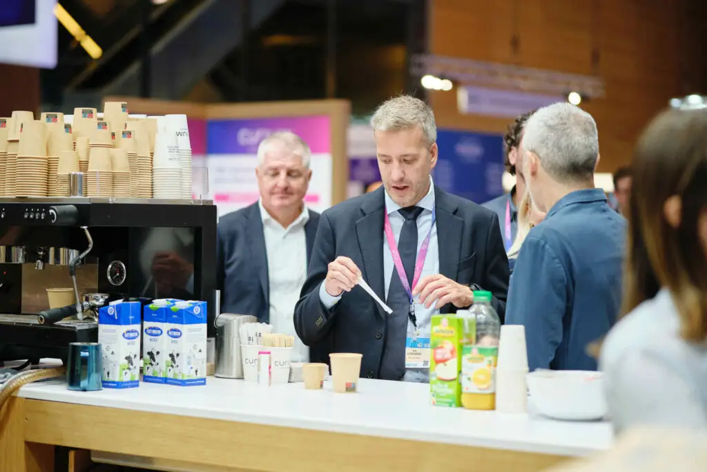 Ein stand auf einem Kongress. Besucher holen sich ein Kaffee ab