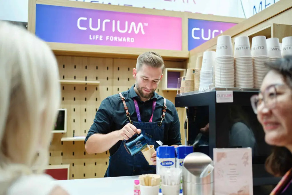 Stand auf einem Kongress. Barista bereitet ein Kaffe zu